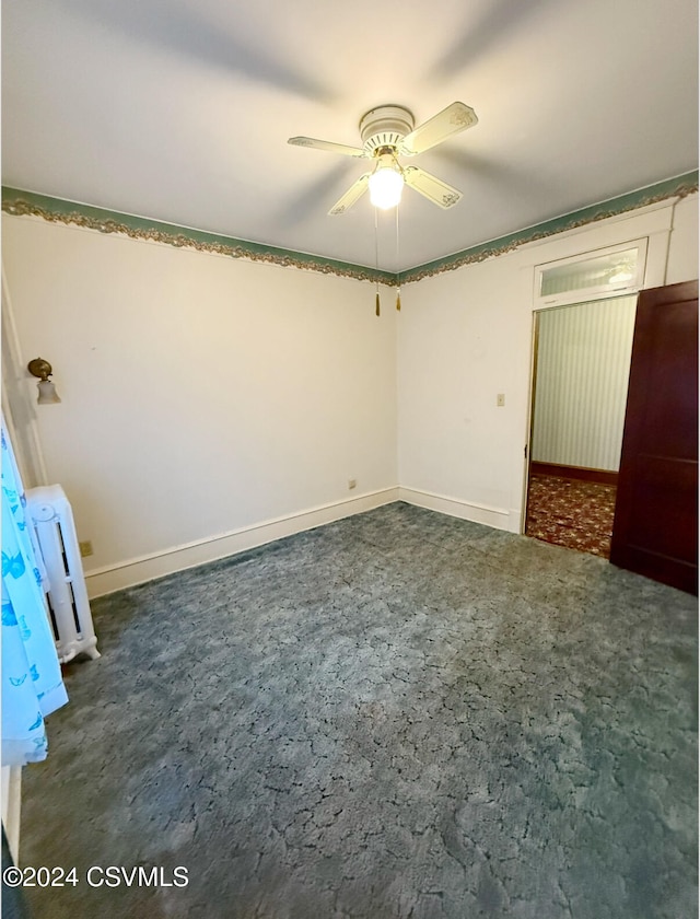 unfurnished bedroom featuring ceiling fan and dark carpet