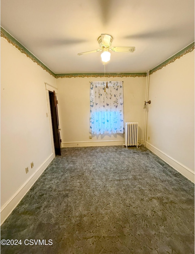 unfurnished room featuring radiator, ceiling fan, and dark colored carpet