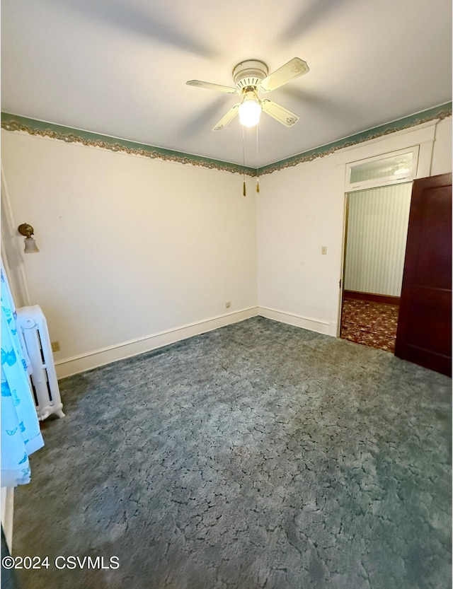 unfurnished bedroom featuring dark carpet and ceiling fan