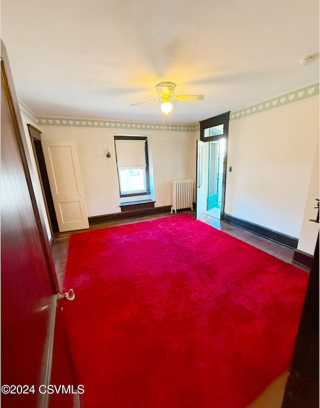 unfurnished room with radiator and ceiling fan