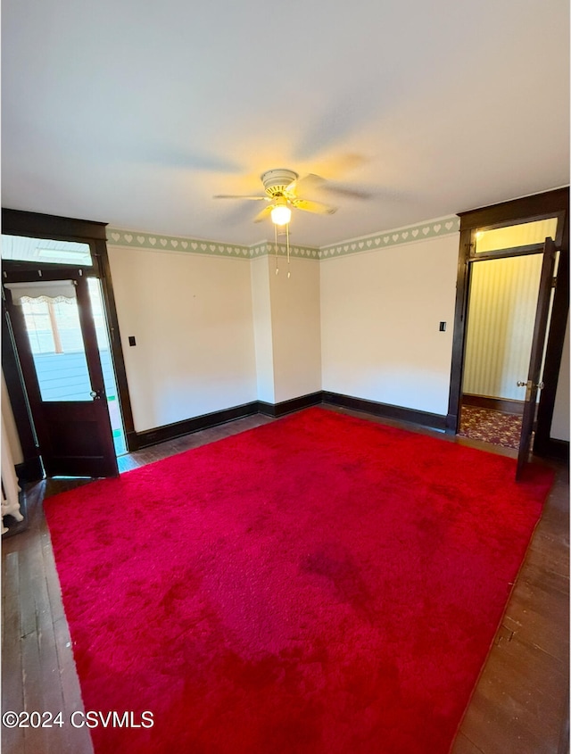 unfurnished room featuring ceiling fan and dark wood-type flooring