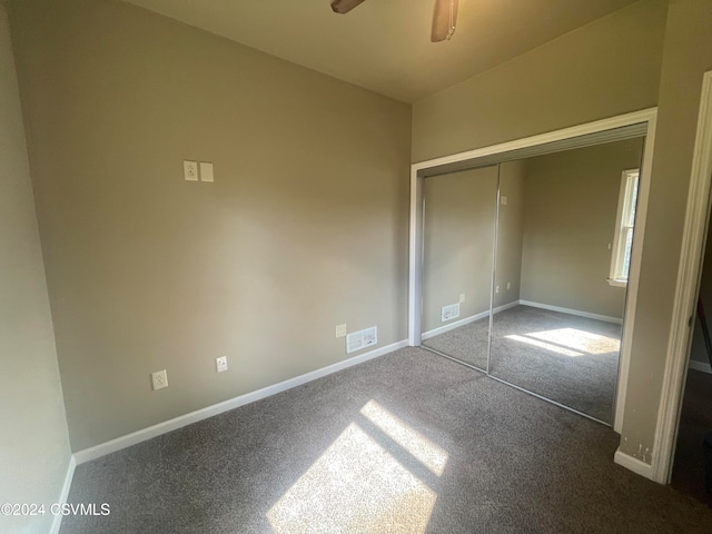 unfurnished bedroom featuring ceiling fan, a closet, and carpet