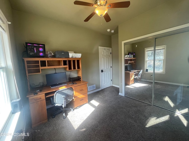 unfurnished office featuring dark colored carpet and ceiling fan