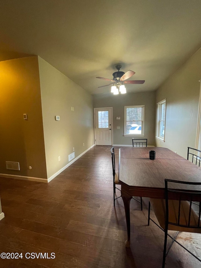 unfurnished dining area featuring ceiling fan and dark hardwood / wood-style flooring