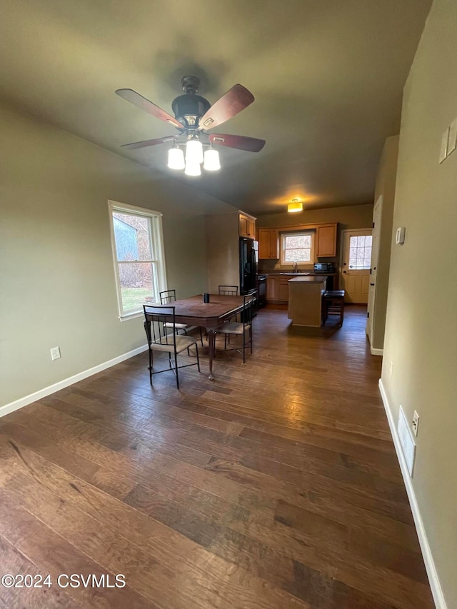 dining space featuring ceiling fan, sink, and dark wood-type flooring