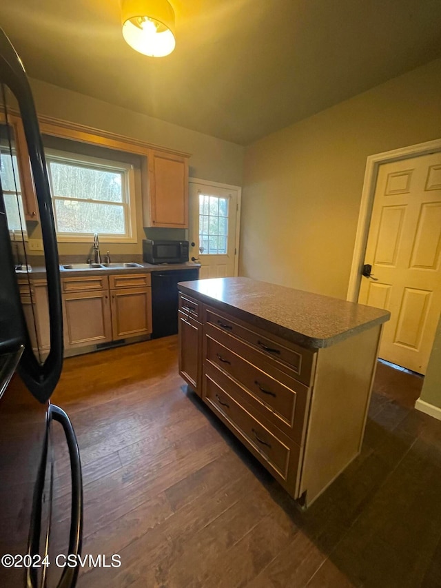 kitchen featuring a center island, black appliances, dark hardwood / wood-style floors, and sink