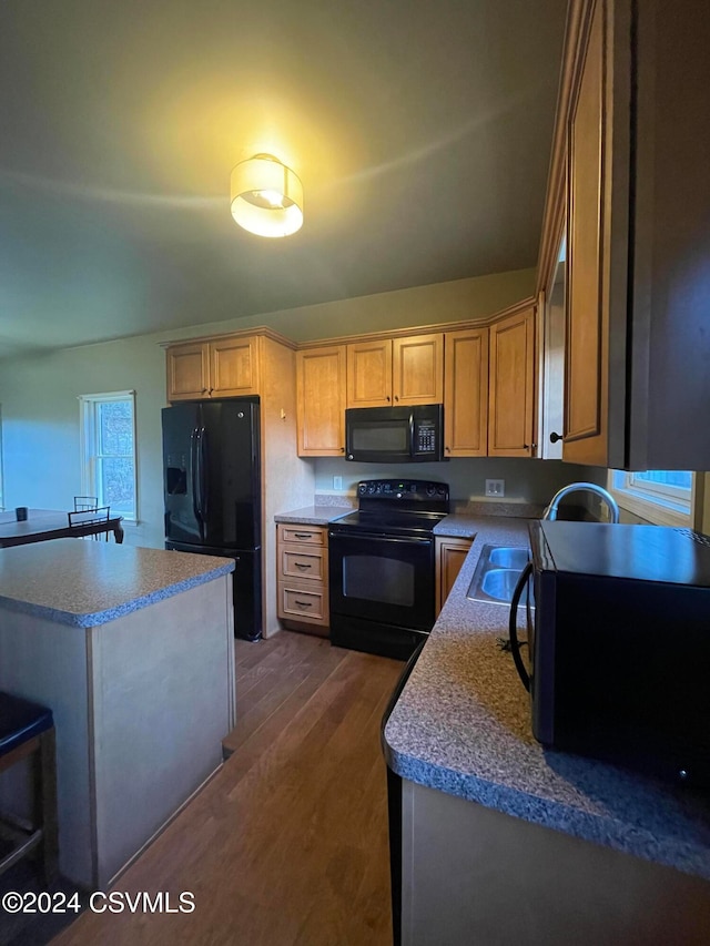 kitchen featuring black appliances, sink, and dark wood-type flooring