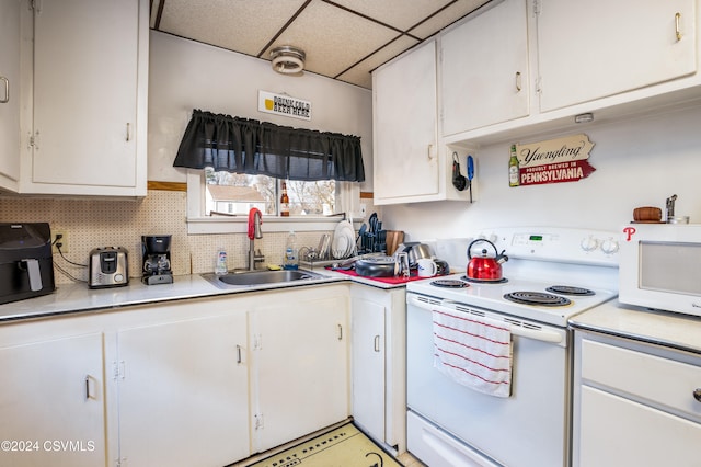 kitchen with decorative backsplash, a drop ceiling, sink, white range with electric cooktop, and white cabinetry