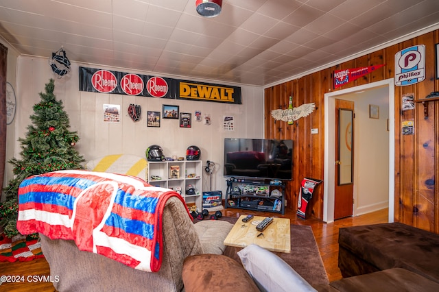 living room with hardwood / wood-style flooring and wooden walls