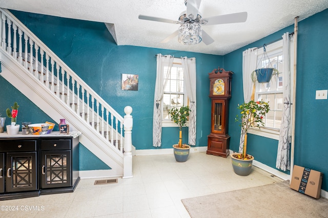 interior space with a textured ceiling and ceiling fan