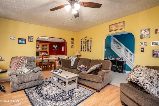 living room with wood-type flooring, a textured ceiling, and ceiling fan