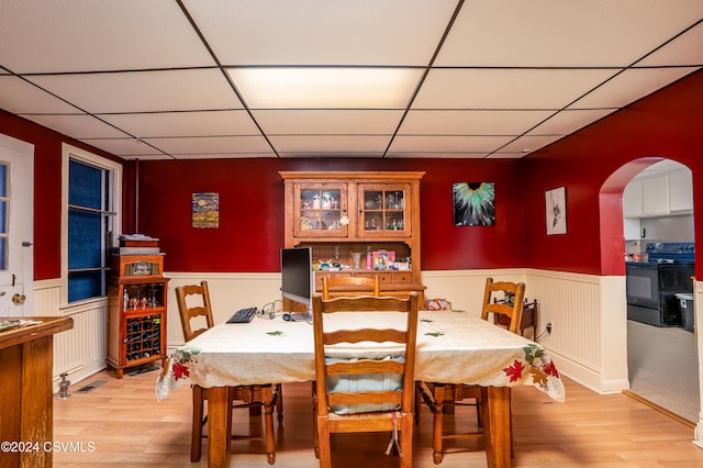 dining room with a drop ceiling and light hardwood / wood-style floors