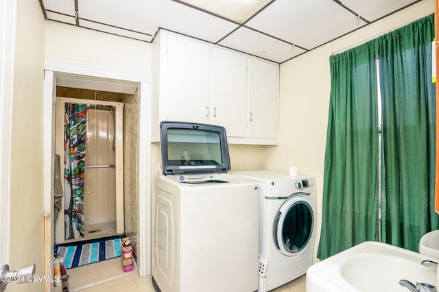 laundry area featuring washing machine and dryer and light tile patterned floors