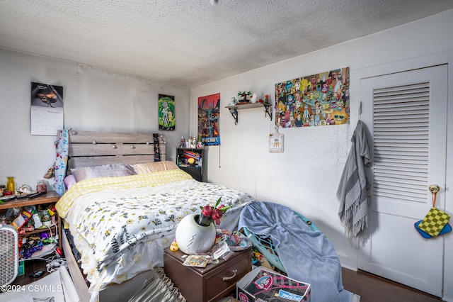 bedroom with hardwood / wood-style flooring and a textured ceiling