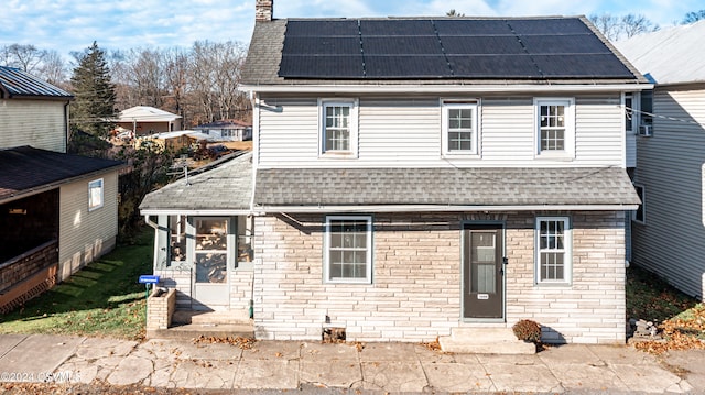 view of front facade featuring solar panels