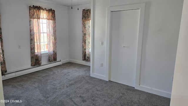 unfurnished room featuring a baseboard radiator and dark colored carpet