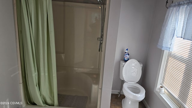 bathroom featuring toilet and walk in shower