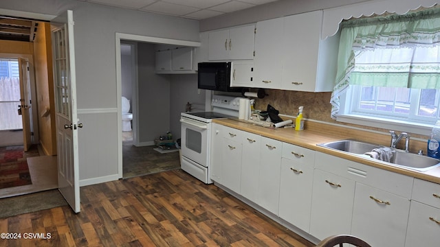 kitchen with dark hardwood / wood-style flooring, white cabinets, a drop ceiling, white range with electric cooktop, and sink