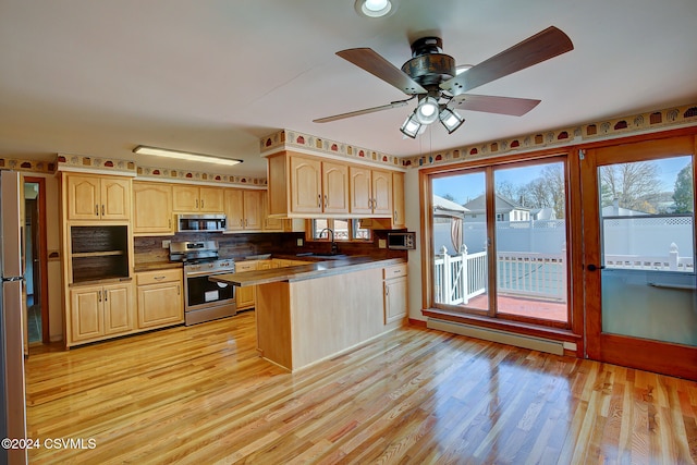 kitchen featuring sink, light wood-type flooring, baseboard heating, light brown cabinetry, and stainless steel appliances