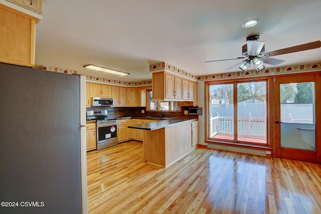 kitchen featuring sink, a baseboard heating unit, kitchen peninsula, light hardwood / wood-style floors, and appliances with stainless steel finishes