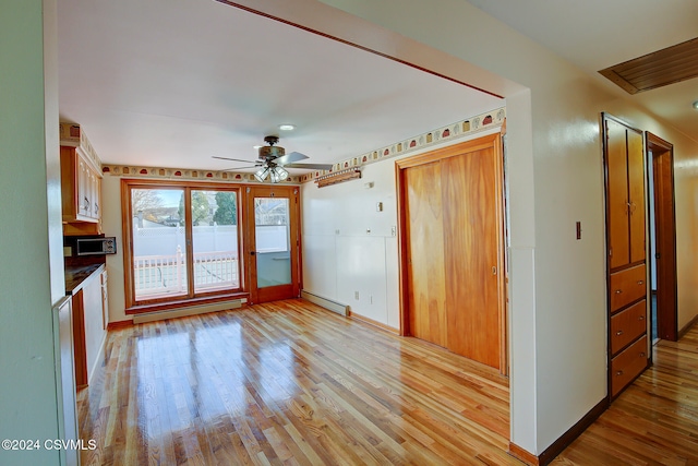 kitchen featuring ceiling fan, light wood-type flooring, and a baseboard heating unit