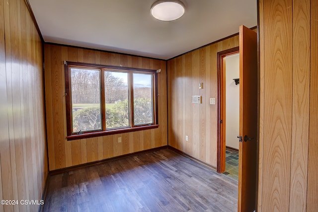 spare room featuring hardwood / wood-style flooring and wood walls