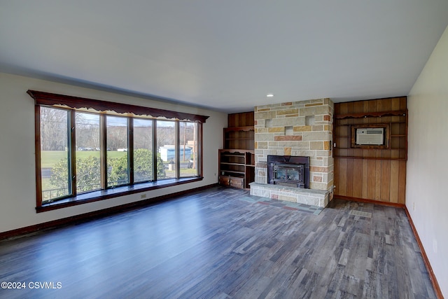 unfurnished living room featuring dark hardwood / wood-style floors and a wall unit AC