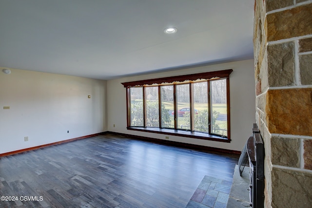 unfurnished living room featuring a fireplace and dark hardwood / wood-style floors