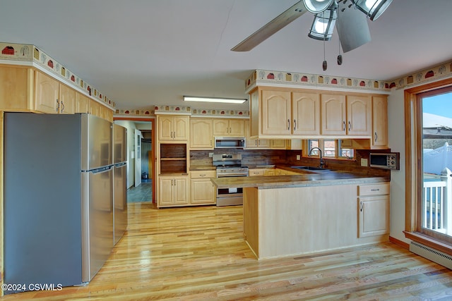 kitchen with appliances with stainless steel finishes, light hardwood / wood-style flooring, and light brown cabinetry