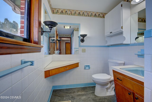 bathroom featuring vanity, tile walls, and toilet