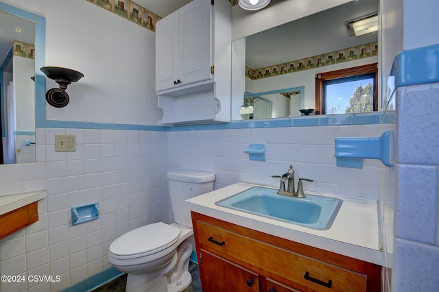 bathroom featuring vanity, toilet, and tile walls