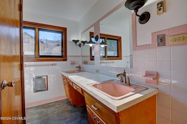 bathroom with vanity and tile walls