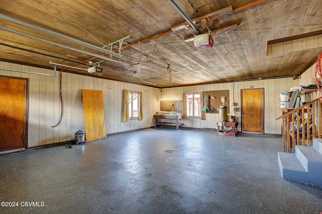 garage featuring wood ceiling, wood walls, and a garage door opener