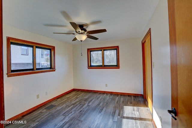 spare room with dark hardwood / wood-style floors, a healthy amount of sunlight, and ceiling fan