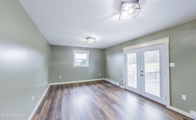 empty room featuring french doors, dark hardwood / wood-style floors, and a baseboard heating unit