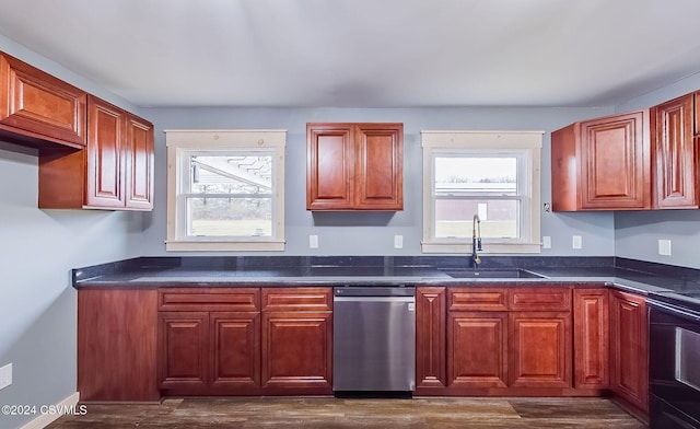 kitchen featuring dark stone counters, black range oven, sink, stainless steel dishwasher, and dark hardwood / wood-style flooring