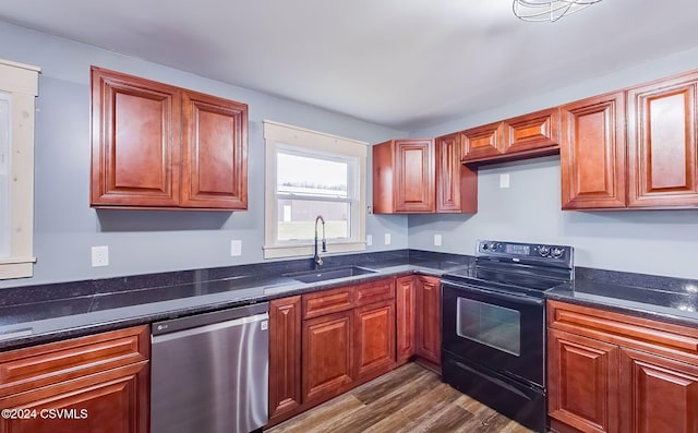 kitchen featuring sink, black range with electric cooktop, stainless steel dishwasher, dark stone countertops, and hardwood / wood-style flooring