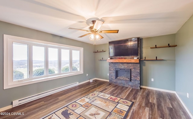 unfurnished living room featuring ceiling fan, wood-type flooring, a fireplace, and a baseboard heating unit