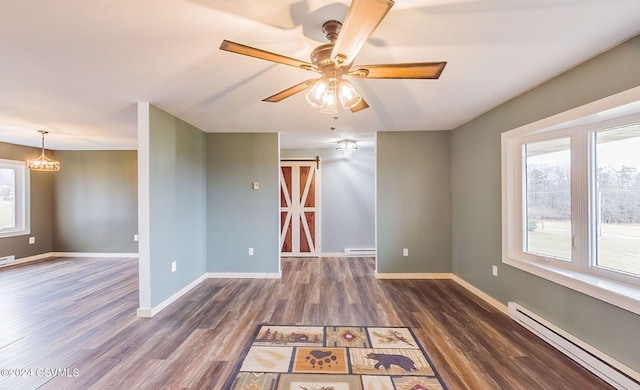 empty room with dark hardwood / wood-style flooring, a baseboard radiator, and ceiling fan with notable chandelier