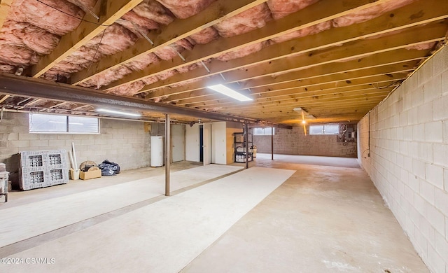 basement with gas water heater and a healthy amount of sunlight