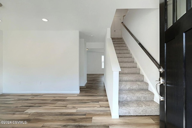 stairs featuring hardwood / wood-style floors