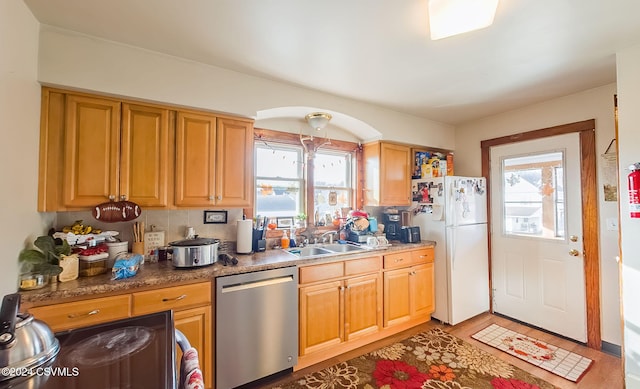 kitchen featuring dishwasher, white fridge, plenty of natural light, and sink