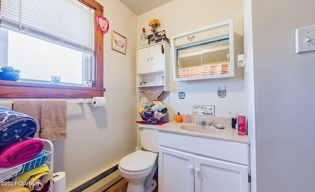 bathroom featuring vanity, hardwood / wood-style flooring, toilet, and a baseboard heating unit