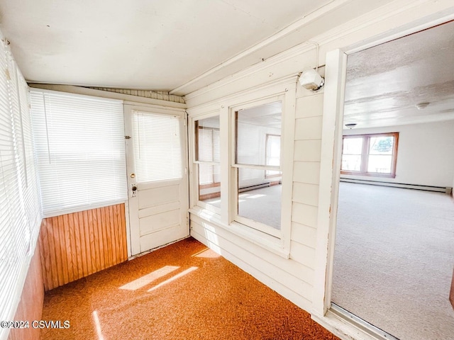 unfurnished sunroom featuring vaulted ceiling and a baseboard radiator