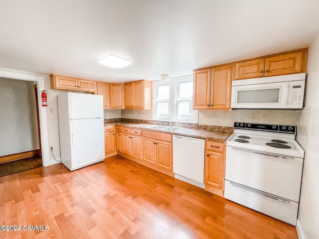 kitchen with light wood-type flooring, white appliances, sink, and tasteful backsplash