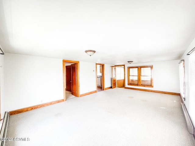 carpeted empty room featuring baseboard heating