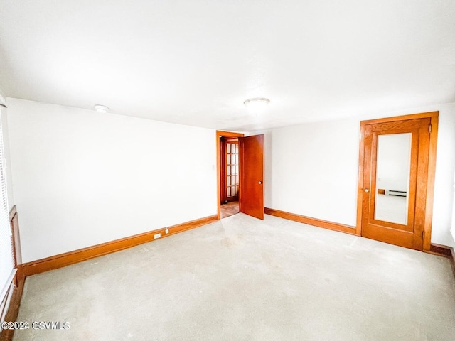 carpeted spare room with a baseboard radiator