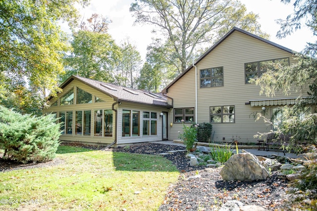 back of property with a yard and a sunroom