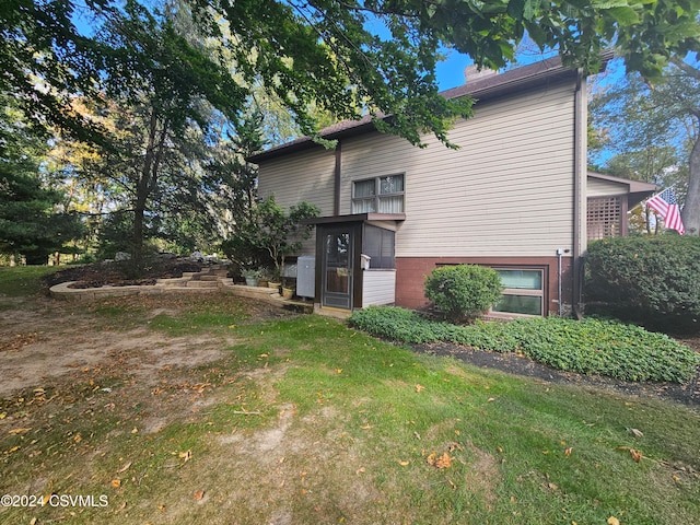 back of house featuring a lawn