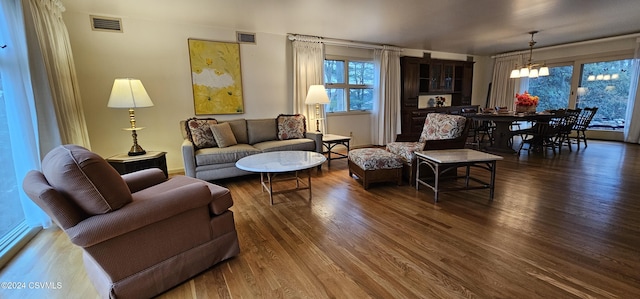 living room with a notable chandelier and dark hardwood / wood-style floors